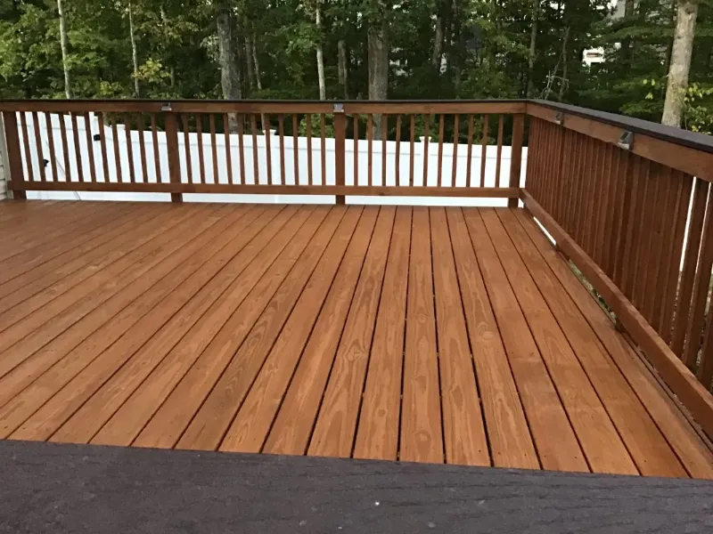 Wooden deck with brown rails overlooking trees Wooden deck with brown rails overlooking trees
